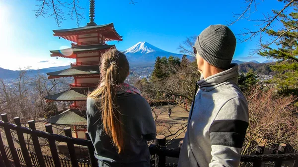 一对夫妇站在日本竹里都宝塔旁边 指着后面的富士山 他们玩得很开心 探索和欣赏美丽的风景 荷莉山晴朗而晴朗的一天 — 图库照片
