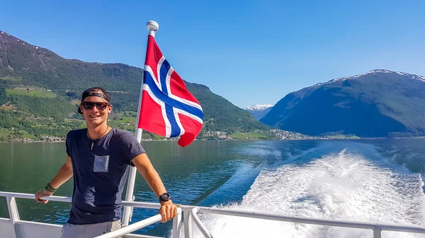 Joven Apoyado Una Barandilla Barco Con Una Bandera Noruega Ondeando Fotos de stock libres de derechos