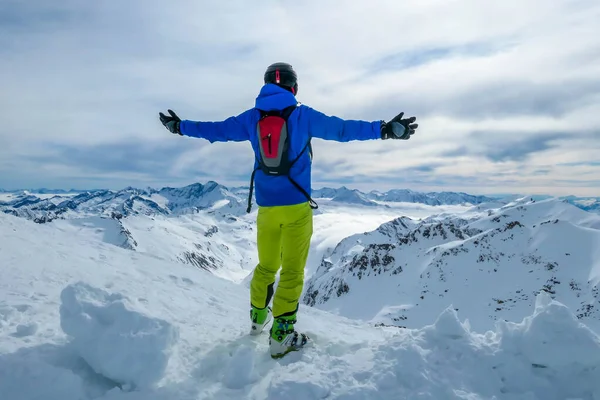 Skiing young man standing on the snow in Moelltaler Gletscher, Austria, enjoying the view. Lots of snow in the mountains. Endless Alps chain. Winter wonderland, paradise. Calmness and happiness.