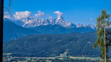 A panoramic view, seen from Oswaldiberg, on the city of Villach in Carinthia, Austrian Alps. The mountains in the back are very steep and sharp. The ski-jump arena can be seen in the distance clipart