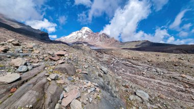 A cloudless view on Mount Kazbeg in Caucasus, Georgia. There slopes are barren and stony below the snow-capped peak and the Gergeti Glacier. Tranquillity. Natural remedy. Massive glacier foot clipart