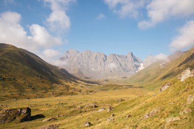 Gürcistan, Kazbegi Bölgesi 'ndeki Büyük Kafkasya Dağları' ndaki Chaukhi topluluğunun keskin dağ zirvelerine panoramik bir manzara. Vadi Roshka taşlarıyla dolu. Gürcü Dolomitler.