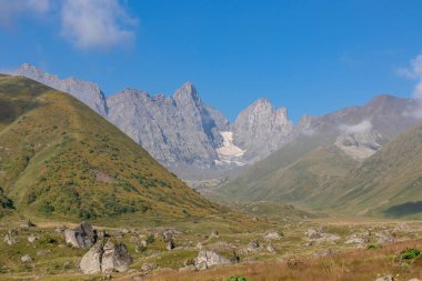 Gürcistan, Kazbegi Bölgesi 'ndeki Büyük Kafkasya Dağları' ndaki Chaukhi topluluğunun keskin dağ zirvelerine panoramik bir manzara. Vadi Roshka taşlarıyla dolu. Gürcü Dolomitler.