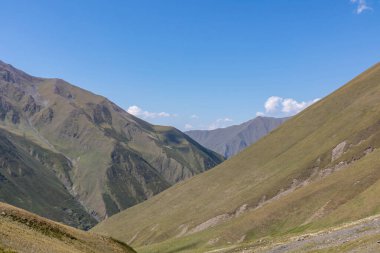 Gürcistan, Kazbegi Bölgesi 'ndeki Büyük Kafkas Dağları Sıradağları' ndaki Chaukhi tepelerinin yeşil tepeleri ve sivri tepeleri panoramik bir manzara. Seyahat tutkusu. Temiz Gökyüzü. Koşun!
