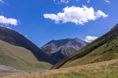 Gürcistan, Kazbegi Bölgesi 'ndeki Büyük Kafkasya Dağları' ndaki Chaukhi topluluğunun yüksek dağ zirvelerinde panoramik bir manzara. Yeşil yemyeşil otlakları olan bir vadi. Seyahat tutkusu. Uzak konum.