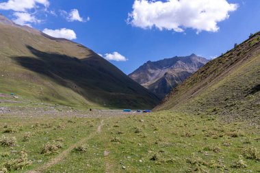 Gürcistan, Kazbegi Bölgesi 'ndeki Büyük Kafkasya Dağları' ndaki Chaukhi topluluğunun yüksek dağ zirvelerinde panoramik bir manzara. Yeşil yemyeşil otlakları olan bir vadi. Seyahat tutkusu. Uzak konum.