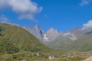 Gürcistan, Kazbegi Bölgesi 'ndeki Büyük Kafkasya Dağları' ndaki Chaukhi topluluğunun keskin dağ zirvelerine panoramik bir manzara. Vadi Roshka taşlarıyla dolu. Gürcü Dolomitler.