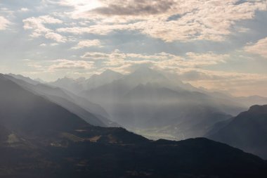 Amazing view on the village of Mestia in the Greater Caucasus Mountain Range, Country of Georgia. The morning fog covers the valley, while the first sun rays appear on the snowy mountain peaks.Sunrise clipart