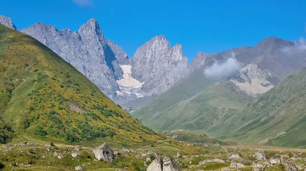 Gürcistan, Kazbegi Bölgesi 'ndeki Büyük Kafkasya Dağları' ndaki Chaukhi topluluğunun keskin dağ zirvelerine panoramik bir manzara. Vadi Roshka taşlarıyla dolu. Gürcü Dolomitler.