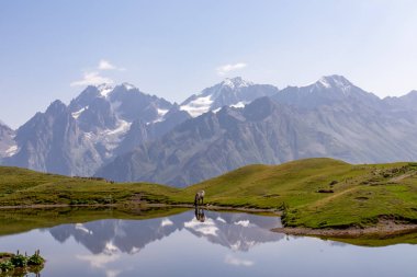 Koruldi Gölü 'nde otlayan bir at, Gürcistan' ın Yukarı Svaneti bölgesindeki Kafkasya Dağları 'ndaki Mestia yakınlarındaki bir dağ sırasına benzer bir manzaraya sahip. Vahşi yaşam gözlemi.