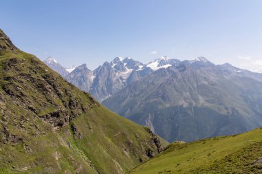 An amazing panoramic view on the mountain ridges near Mestia in the Greater Caucasus Mountain Range, Samegrelo-Upper Svaneti, Country of Georgia. The sharp peaks are covered in snow. Wanderlust clipart