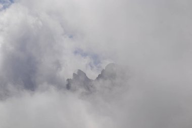 Bulutlar, Gürcistan, Kazbegi Bölgesi 'ndeki Büyük Kafkasya Dağları' ndaki Chaukhi topluluğunun keskin dağ zirvelerini neredeyse rahatlıkla kaplıyor. Yürüyüş. Gürcü Dolomitler. Bulut manzarası