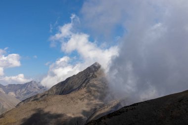 Gürcistan, Kazbegi Bölgesi 'ndeki Büyük Kafkasya Dağları' ndaki Chaukhi Geçidi 'nin eteklerinde bulutlar birikiyor. Mountain Ridges, Yürüyüş. Gürcü Dolomitler. Bulut manzarası