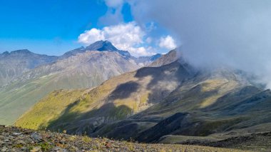 Gürcistan, Kazbegi Bölgesi 'ndeki Büyük Kafkasya Dağları' ndaki Chaukhi Geçidi 'nin eteklerinde bulutlar birikiyor. Mountain Ridges, Yürüyüş. Gürcü Dolomitler. Bulut manzarası