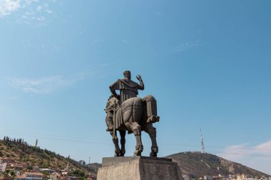 Kral Vakhtang Gorgasali 'nin Tiflis şehir merkezindeki heykelinin geriye dönük panoramik görüntüsü. Heykeller Metekhi Kilisesi' nin önünde duruyor. Eski ve tarihi bir bina..