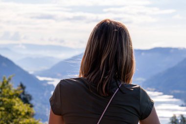 Avusturya Alpleri, Carinthia 'da Oswaldiberg Gölü manzaralı bir şapelin izleme platformunda duran bir kadın. Kadın panoramik manzarayı seviyor. Sabah havası, Özgürlük