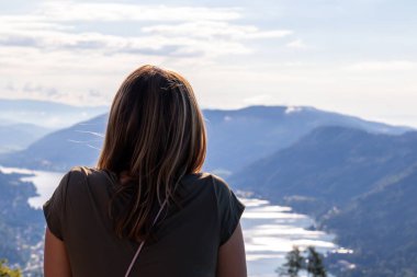 Avusturya Alpleri, Carinthia 'da Oswaldiberg Gölü manzaralı bir şapelin izleme platformunda duran bir kadın. Kadın panoramik manzarayı seviyor. Sabah havası, Özgürlük