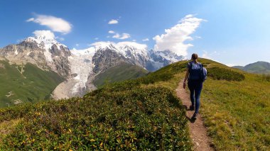 Tetnuldi, Gistola, Lakutsia ve Svaneti Bölgesi 'nin Büyük Kafkasya Dağları' ndaki Adishi Buzulu 'nun tepelerinde panoramik manzaralı yürüyüş yapan bir kadın. Gezgin Şehveti Bölgesi, Gürcistan' da.