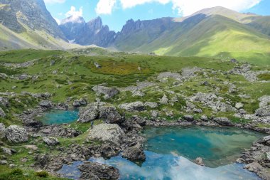 Georgia, Kazbegi Bölgesi 'ndeki Büyük Kafkasya Dağları' ndaki Renkli Abudelauri Dağları 'nın keyfini çıkaran bir adam. Seyahat ve açık hava seyahati. Alp otlakları. Yansıma Gölü.