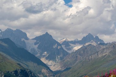Gürcistan 'daki yüksek Kafkasya dağlarında panoramik bir manzara. Arkada yüksek, karlı tepeler var. Tepelerin üzerindeki kalın bulutlar. Idyllic manzara. Sakinlik ve meditasyon. Doğal tedavi.