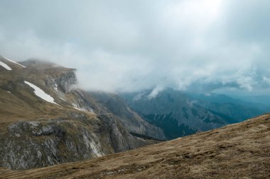 Avusturya 'nın Yukarı Styria bölgesindeki Hochschwab Bölgesi' nin bulut kaplı dağ zirvelerindeki dağlık bir çayırda manzaralı yürüyüş patikası. Alpler, Avrupa 'da yağmurlu bir bahar günü. Hava yüksek irtifada değişir. Rüzgâr