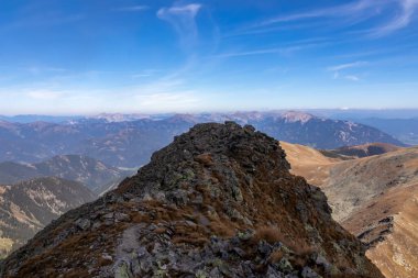 Aşağı Tauern sıradağları, Styria, Avusturya ve Avrupa 'da bir izleme noktasının kenarına giden panoramik yürüyüş. Seckau Alplerinde güneşli bir sonbahar günü. Kuru, tepelik, çıplak arazide yol. Uzak güzellik