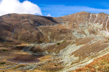 Aşağı Tauern sıradağlarında Goldlacke Gölü ve Haemerkogel manzarası, Styria, Avusturya, Avrupa. Seckau Alplerinde güneşli bir sonbahar günü. Seckauer Zinken 'e kuru ve çıplak arazide manzaralı yürüyüş patikası
