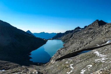 Avusturya, Carinthia 'daki Hohe Tauern Alpleri' nin panoramik manzarası. Moelltaler buzulunda bir göl yansıması ve su deposu. Hohe Tauern Ulusal Parkı. Gölgedeki vadi