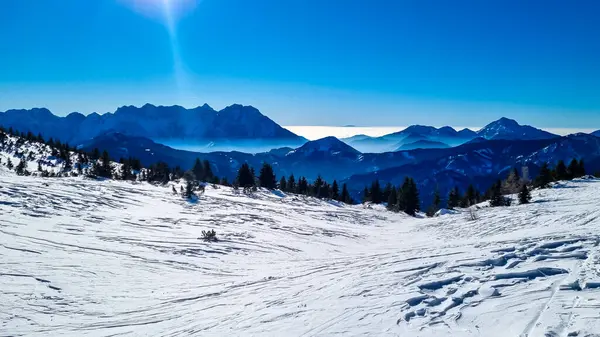 Avusturya, Carinthia 'daki Karawanks dağlarının karla kaplı tepelerinde panoramik manzara. Julian Alps. Avusturya Alpleri, Avrupa 'da kış harikalar diyarı. Kayak turu, kar ayakkabısı yürüyüşü. Hochobir. Mavi sisli tepeler.