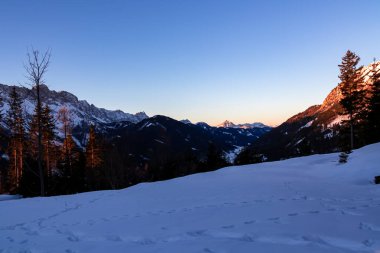 Avusturya, Carinthia 'daki Karawanks dağlarının tepesinde gün doğumu. Julian Alps. Avusturya Alpleri, Avrupa 'da şafak vakti kış harikalar diyarı manzarası. Kayak turu, kar ayakkabısı yürüyüşü. Hochobir.