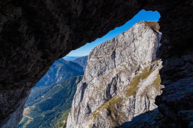 Avusturya 'nın Yukarı Styria bölgesindeki Hochschwab bölgesinde Zinken Dağı' ndaki kayalık bir delikten panoramik bir manzara. Avrupa 'daki Alpler' in yüksek, keskin kaya duvarları. Mağara. Özgürlük kavramı. Kireçtaşı