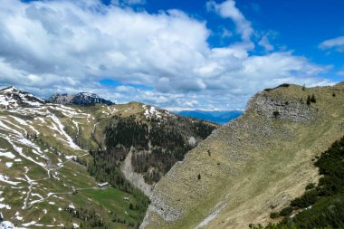 Karawanks, Carinthia, Avusturya 'da ilkbaharda panoramik manzaralı Hahnkogel (Klek) dağı zirvesi. Avusturya, Slovenya, İtalya sınırlarında. Triglav Ulusal Parkı. Alp çayırları. Sadaka. Eriyen kar alanları