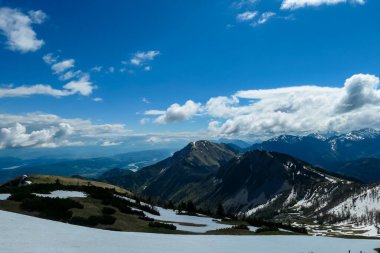 İlkbaharda Frauenkogel yakınlarında Karawanks, Carinthia, Avusturya 'daki dağ zirvelerinde panoramik manzara. Avusturya, Slovenya, İtalya sınırlarında. Triglav Ulusal Parkı. Alp çayırları. Sadaka. Eriyen kar alanları
