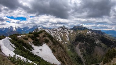 Karawanks, Carinthia, Avusturya 'da ilkbaharda panoramik manzaralı Hahnkogel (Klek) dağı zirvesi. Avusturya, Slovenya, İtalya sınırlarında. Triglav Ulusal Parkı. Alp çayırları. Sadaka. Eriyen kar alanları