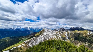 Karawanks, Carinthia, Avusturya 'da ilkbaharda panoramik manzaralı Hahnkogel (Klek) dağı zirvesi. Avusturya, Slovenya, İtalya sınırlarında. Triglav Ulusal Parkı. Alp çayırları. Sadaka. Eriyen kar alanları