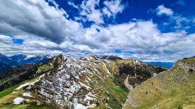 Karawanks, Carinthia, Avusturya 'da ilkbaharda panoramik manzaralı Hahnkogel (Klek) dağı zirvesi. Avusturya, Slovenya, İtalya sınırlarında. Triglav Ulusal Parkı. Alp çayırları. Sadaka. Eriyen kar alanları