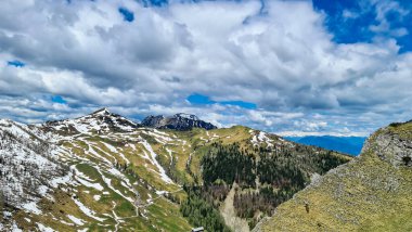 Karawanks, Carinthia, Avusturya 'da ilkbaharda panoramik manzaralı Hahnkogel (Klek) dağı zirvesi. Avusturya, Slovenya, İtalya sınırlarında. Triglav Ulusal Parkı. Alp çayırları. Sadaka. Eriyen kar alanları