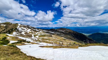 İlkbaharda Frauenkogel yakınlarında Karawanks, Carinthia, Avusturya 'daki dağ zirvelerinde panoramik manzara. Avusturya, Slovenya, İtalya sınırlarında. Triglav Ulusal Parkı. Alp çayırları. Sadaka. Eriyen kar alanları