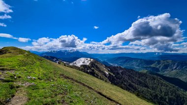 Frauenkogel 'den Karawanks ve Julian Alps, Carinthia, Avusturya' daki dağ tepelerinde panoramik manzara. Avusturya, Slovenya, İtalya sınırlarında. Triglav Ulusal Parkı. İlkbaharda Alp çayırları. Orman