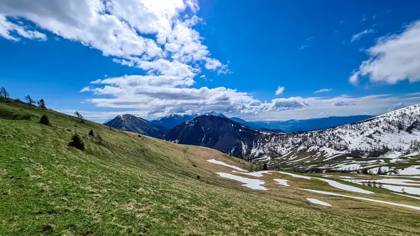 İlkbaharda Frauenkogel yakınlarında Karawanks, Carinthia, Avusturya 'daki dağ zirvelerinde panoramik manzara. Avusturya, Slovenya, İtalya sınırlarında. Triglav Ulusal Parkı. Alp çayırları. Sadaka. Eriyen kar alanları