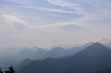 Avusturya, Carinthia 'daki Karawanklar' ın dağlık dağ zincirlerinin manzarası. Zirveler sabah sisiyle örtülüdür. Mistik titreşimler. Açık ve güneşli bir gün. Huzur. Görüntü: Ferlacher Spitze, Alpler