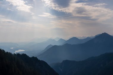 Avusturya, Carinthia 'daki Karawanklar' ın dağlık dağ zincirlerinin manzarası. Zirveler sabah sisiyle örtülüdür. Mistik titreşimler. Açık ve güneşli bir gün. Huzur. Görüntü: Ferlacher Spitze, Alpler