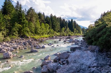 Villach, Carinthia, Avusturya 'daki Dobratsch doğal parkında akan Gail Nehri. Gailtaler ve Alpler. Riverbank kocaman kayalarla dolu. Kristal berrak suda yüzmek
