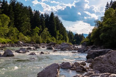 Villach, Carinthia, Avusturya 'daki Dobratsch doğal parkında akan Gail Nehri. Gailtaler ve Alpler. Riverbank kocaman kayalarla dolu. Kristal berrak suda yüzmek