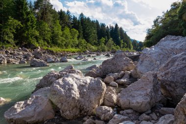 Villach, Carinthia, Avusturya 'daki Dobratsch doğal parkında akan Gail Nehri. Gailtaler ve Alpler. Riverbank kocaman kayalarla dolu. Kristal berrak suda yüzmek