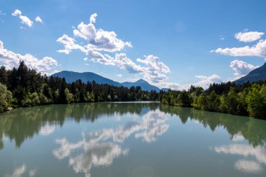 Villach, Carinthia, Avusturya 'daki Dobratsch doğal parkında akan Gail Nehri. Gailtaler ve Alpler. Nehir genişliyor. Kristal berrak sudaki yansımalar. Dağlar