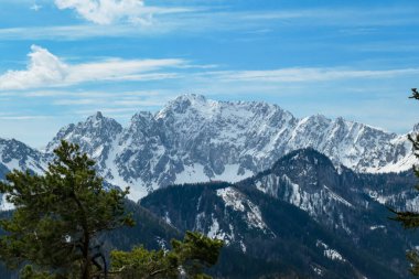 Avusturya 'nın Carinthia kentindeki Sinacher Gupf' a giden Karawanks tepelerinin kar manzaralı manzarası. Wertatscha Dağı, ilkbaharın başlarında sık ormanlardan görülebilir. Güneşli bir günde Rosental. Yürüyüş.