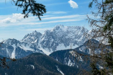 Avusturya 'nın Carinthia kentindeki Sinacher Gupf' a giden Karawanks tepelerinin kar manzaralı manzarası. Wertatscha Dağı, ilkbaharın başlarında sık ormanlardan görülebilir. Güneşli bir günde Rosental. Yürüyüş.