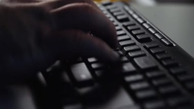 Bilgisayarın klavyesinde el yazısını kapat. Lambaların ışığında gece mesaisinde çalışan bir iş adamı. E-posta gönder, seach yap, internette sörf yap, programcı hayatı kur. Teknoloji konsepti.