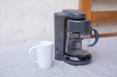 Kahve öğütücüsü ve beyaz arka planlı bir fincan. Tasarım için alanı kopyala. Sabah konsepti.